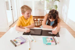 Vivid Pop! Water Based Paint Markers - Pastel - Set Of 8 | OOLY(Vivid Pop Water Based Paint Markers Pastel Set Of 8 Ooly) -Curious Bear Toys Store Two kids coloring on black paper pad with OOLY Vivid Pop Paint Markers wide shot 04c3982b 0293 41c1 a9d1 7f1270781dec